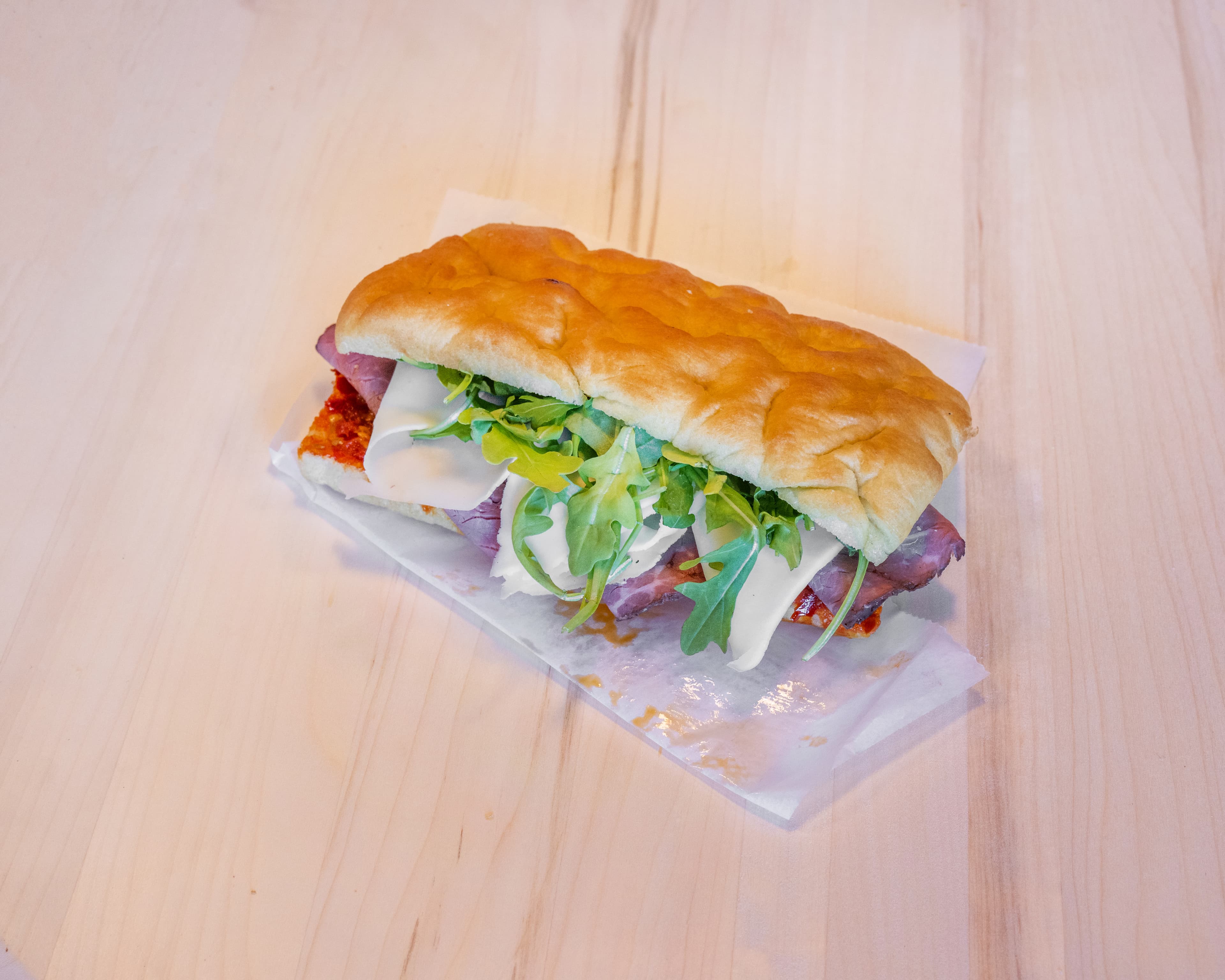 Italian sandwich on rustic bread on a wooden cutting board